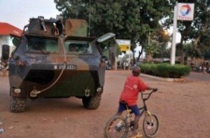 A boy stands next to French soldiers patrolling in an armoured vehicle in Markala on 18 January 2013. (AFP PHOTO)