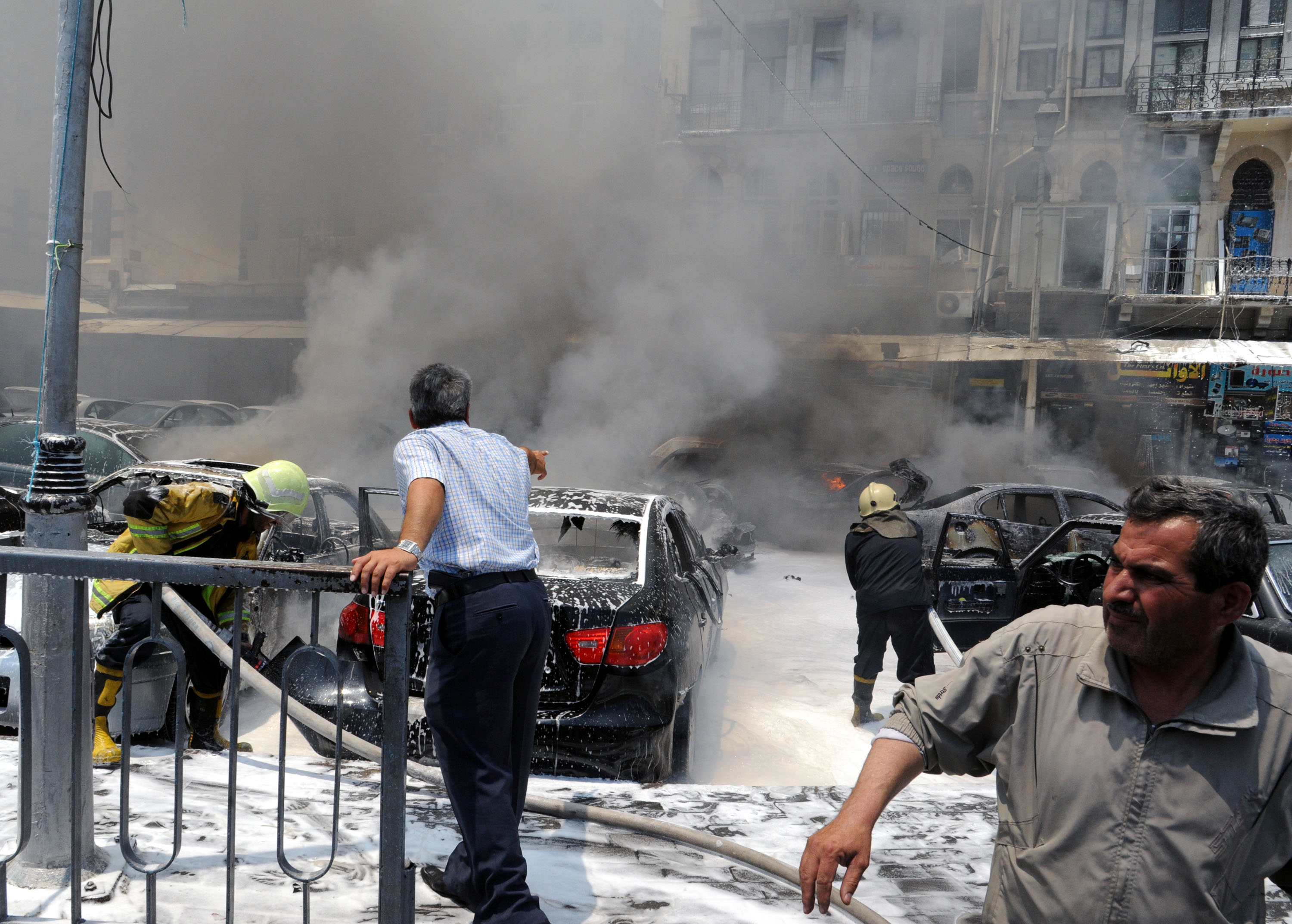 A picture released by the official Syrian news agency SANA shows men at the scene after two huge bombs exploded outside the Palace of Justice in Central Damascus on June 28, 2012 (AFP PHOTO/SANA)