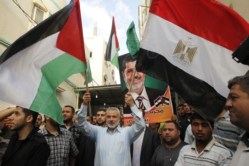 Ismail Haniya, holds up the Palestinian flag and the Egyptian flag as he celebrates Morsi's win AFP