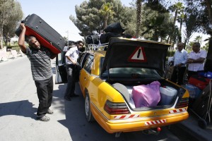 Palestinians unload their belongings from a taxi as the ready to cross to Egypt through the Rafah border crossing between the southern Gaza Strip and Egypt (photo: AFP / Said Khatib)