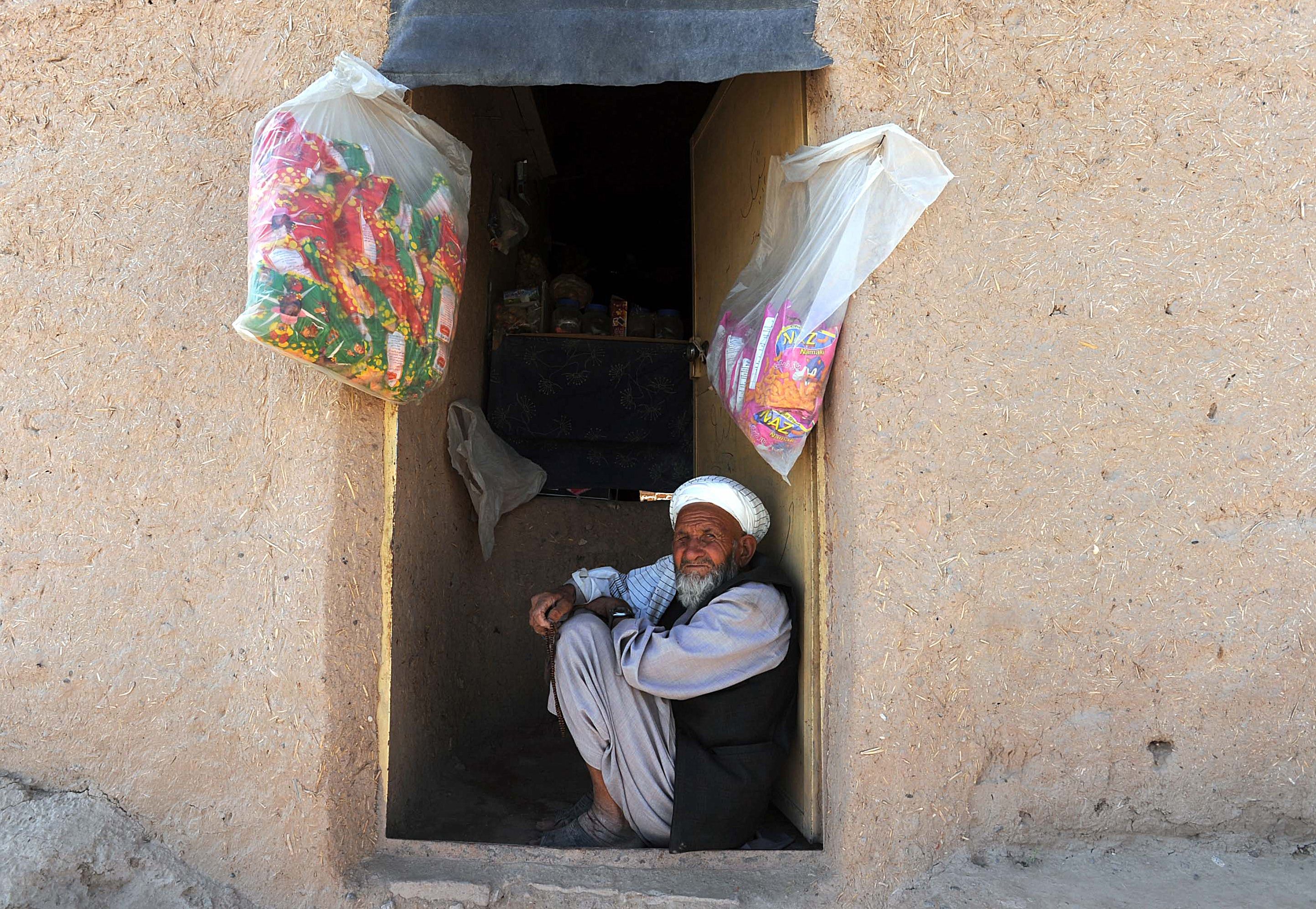 An Afghan shopkeeper sits at the door of his shop in Herat on 29 July 2012 (photo: AFP/Aref KARIMI)