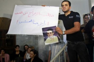 A Christian protester in Gaza city holds a picture of Ramez Abu Amash, a man who converted to Islam, according to his loved ones, through coercion (photo: AFP)