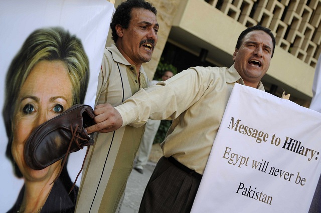 An Egyptian protester shouts slogans as he holds a shoe on a portrait of US Secretary of State Hillary Clinton outside the US embassy in Cairo on July 14, 2012 to protest against her visit to the country. Clinton reaffirmed Washington's "strong" support for Egypt's democratic transition, after talks with newly-elected President Mohamed Morsi (Photo: AFP/MOHAMMED HOSSAM)