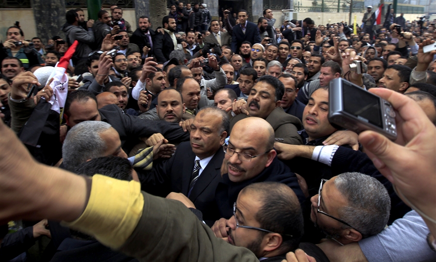Crowds gather as secretary general of Egypt's Freedom and Justice Party (FJP) Saad al-Katatni, center, arrives to attend the newly elected parliament's first session in Cairo (photo AFP)