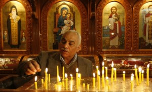A Coptic Christian lights candles during Sunday mass in Alexandria (photo: AFP)