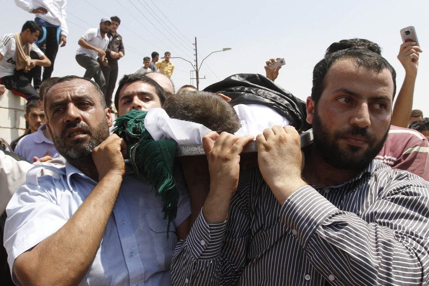 People carry the body of a six-year-old Bilal El-Lababidi during his funeral in the Jordanian town of Ramtha. The boy was allegedly shot dead by the Syrian army as he, his parents, and a dozen other refugees tried to cross the Syrian-Jordanian border to seek refuge in Jordan (photo: AFP/stringer)
