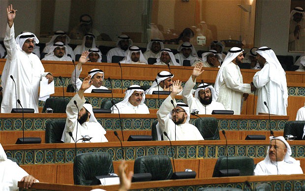 Kuwaiti MPs raise their hands during a parliament session at the National Assembly in Kuwait City (AFP PHOTO)