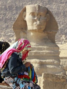 An Egyptian traditional scarf vender sews a scarf in front of the historical site of the great Sphinx in Giza (AFP Photo/Amr Nabil)