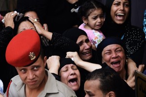 Relatives screams and cry while mourning one of the 16 soldiers killed during an attack on a border crossing post in Northern Sinai, during their funeral on August 7, 2012 in Cairo, Egypt. President Mohamed Morsi ordered security forces to take full control of the Sinai Peninsula and Egypt's army vowed to "avenge" the killings, in which 35 gunmen in Bedouin clothing opened fire on the troops before crossing into the Jewish state in an armoured vehicle, killing five on their side according to the Israelis. AFP PHOTO/GIANLUIGI GUERCIA