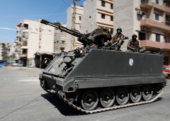 Lebanese soldiers ride an armoured personal carrier equipped with an anti-aircraft heavy machine gun in the Lebanese northern port city of Tripoli on 23 August AFP PHOTO/SAM TARLING