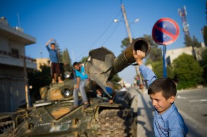 A Syrian boy plays with a tank in the town of Azaz, north of Aleppo, on 11 August  AFP PHOTO / PHIL MOORE 