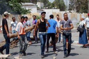 Residents of Kasserine in western Tunisia blocking a road in the centre of the city with a tree during anti-government protests  (AFP PHOTO / Abderrazek)