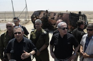 Israeli Defence Minister Ehud Barak (2nd L) and Prime Minister Benjamin Netanyahu (3rd R) speak to the press next to a burnt armoured vehicle near the Kerem Shalom border crossing after unidentified gunmen crossed into Israel from Egypt on 6 August AFP PHOTO / DAVID BUIMOVITCH 