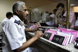 Egyptian custom officials check passports and identity cards as travellers wait on Egyptian side of the Rafah border crossing point on 10 August (AFP PHOTO/STR)