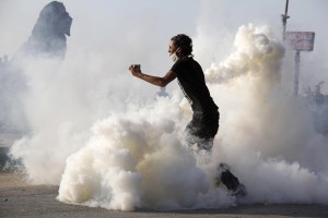 Protester standing amid a fog of tear gas prepares to throw stones towards policemen during the violence that followed the circulation of clips from the "Innocence of Muslims" film AFP PHOTO / MOHAMMED ABDELMONEIM