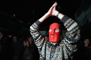 A Russian opposition supporter, wearing a red balaclava, shouts and applauses during a concert in support of Pussy Riot and other political prisoners in a club in Saint-Petersburg  AFP PHOTO / OLGA MALTSEVA