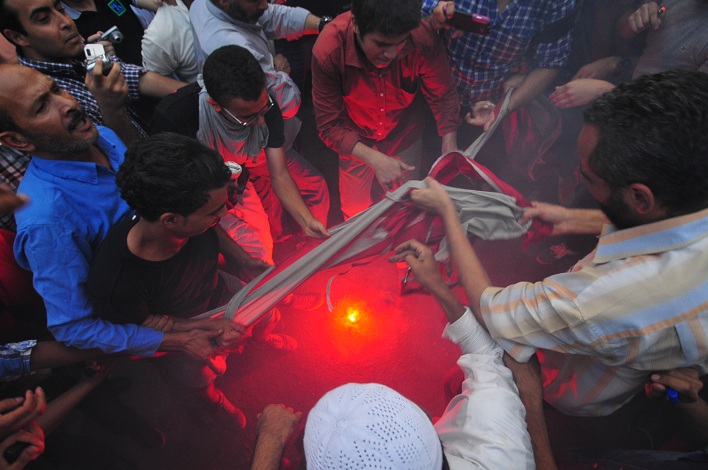Demonstrators burn a United States flag taken from inside the American embassy grounds Hassan Ibrahim / DNE