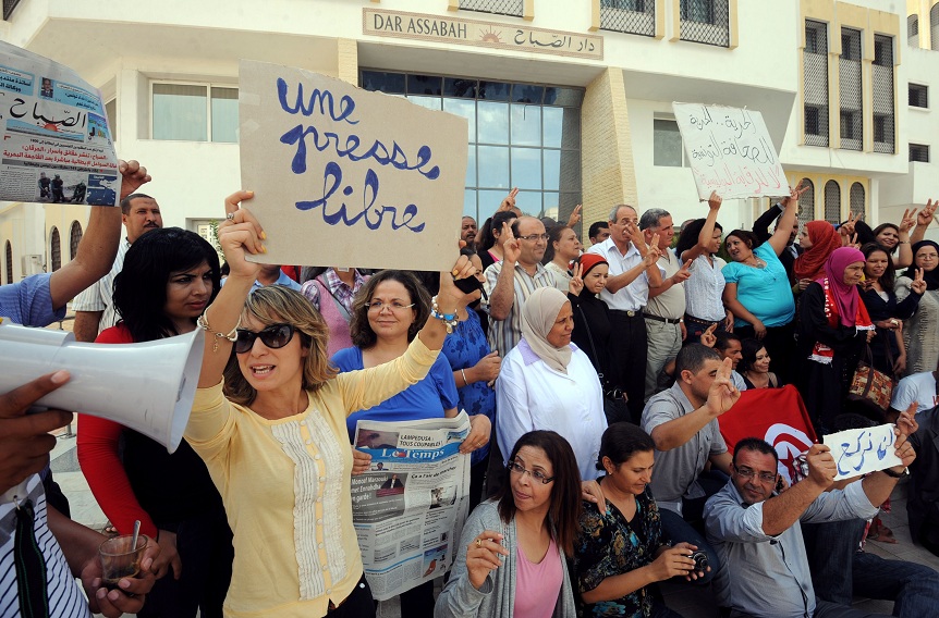 Tunisian journalists of Assabah daily hold signs calling for freedom of the press during a protest in Tunis on 11 September AFP PHOTO / KHALIL