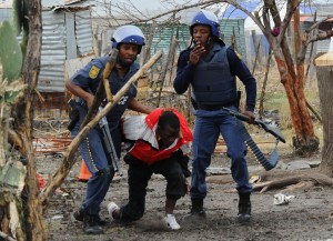 South African police arrest a miner in Marikana on 15 September at Lonmin's platinum mine  AFP PHOTO / ALEXANDER JOE