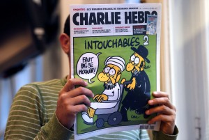 French weekly Charlie Hebdo - cover A man reads the back cover of French satirical weekly Charlie Hebdo which features on the front covera satirical drawing titled "Intouchables 2". Inside pages contain several cartoons caricaturing the Prophet Mohammed AFP PHOTO / THOMAS COEX