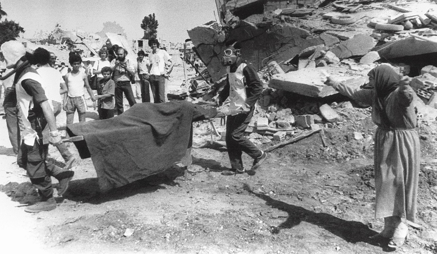 A picture dated 19 September 1982 shows a Palestinian woman crying while civil defence workers remove the body of one of her relatives from the rubble of her home in the Palestinian refugee camp of Sabra, in West Beirut AFP PHOTO
