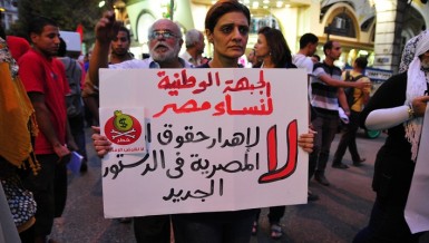 A supporter of the National Front for Egyptian Women joins a march from Talaat Harb Square holding a sign that says “no to wasting women’s rights in the new constitution“  Hassan Ibrahim / DNE