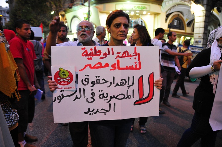 A supporter of the National Front for Egyptian Women joins a march from Talaat Harb Square holding a sign that says “no to wasting women’s rights in the new constitution“ Hassan Ibrahim / DNE