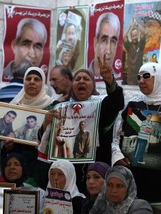 Palestinian women hold pictures of their relatives held in Israeli jails during a sit-in outside the Red Crescent offices near the West Bank city of Ramallah on 18 September (File photo)  AFP PHOTO / ABBAS MOMANI