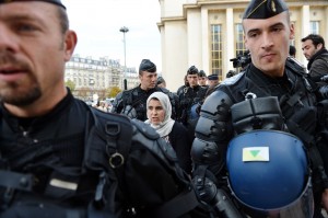 French mobile policemen escort a Muslim woman for an identity control in Paris as police deployed in several areas of the city to enforce a ban on protests over films and cartoons mocking the Prophet Mohammed  AFP PHOTO / ERIC FEFERBERG