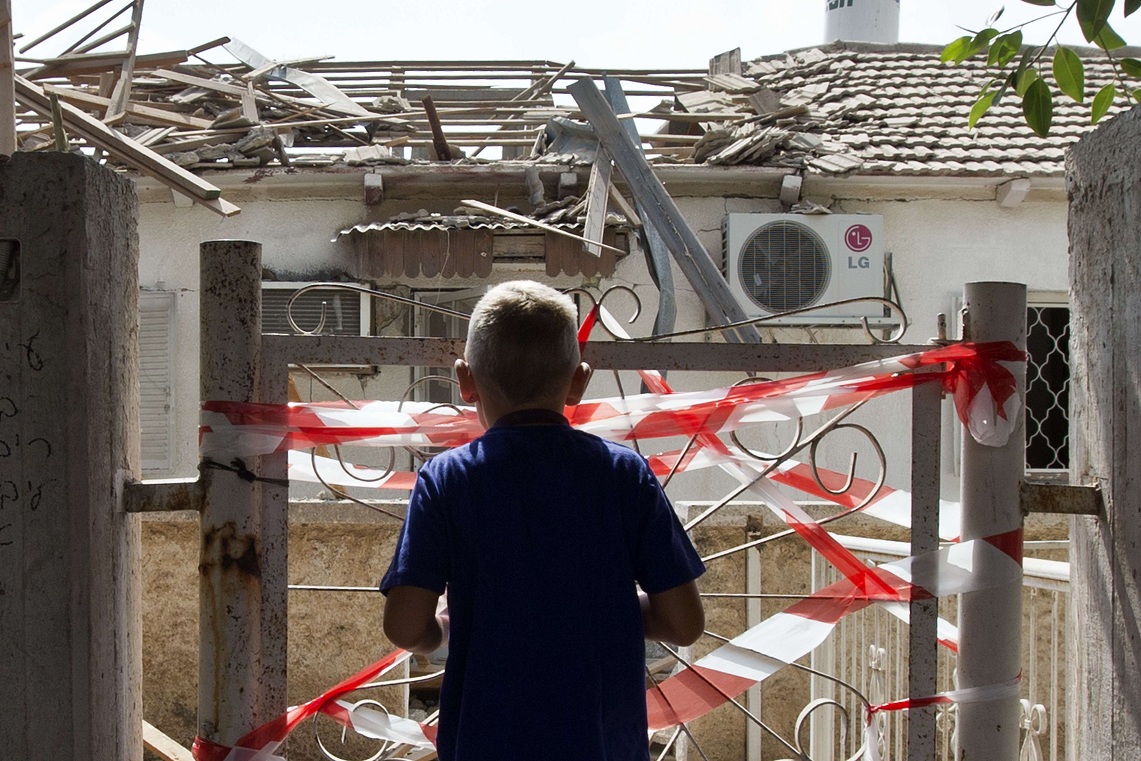 Israeli youth looks at the damages after a rocket fired by Palestinian militants from the Gaza Strip hit a house in the southern Israeli town of Netivot AFP PHOTO / JACK GUEZ