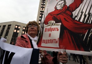 Woman takes part in an anti-Putin protest in central in Moscow, the poster reads "To take away and divide" AFP PHOTO / ANDREY SMIRNOV