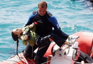 A diver carries a young girl, after a boat carrying illegal immigrants trying to reach Europe capsized in waters off western Turkey near Izmir AFP PHOTO / IHLAS NEWS AGENCY