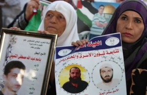 Palestinian women hold pictures of prisoners held in Israeli jails during a protest in Ramallah  AFP / Abbas Momani