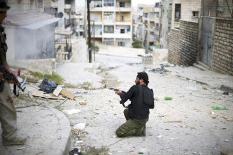A fighter with the Free Syria Army fires his weapon during a skirmish with regime forces in the Izza districtb of Aleppo on Tuesday. Syrian troops and rebels clashed near Aleppo's international airport on Wednesday, a watchdog said, but it was unclear whether it was part of a rebel offensive to seize the facility AFP Photo