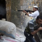 A Syrian rebel fires towards regime forces as his comrade ducks for cover during clashes in the old city of Aleppo in northern Syria AFP PHOTO / MIGUEL MEDINA