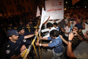 A Kuwaiti demonstrator holds a sign reading "Don't miss with the people's will" as fellow protesters try to take down barricades during a demonstration outside the national assembly in Kuwait City late on October 15, 2012. (AFP Photo/ Yasser Al-Zayyat)
