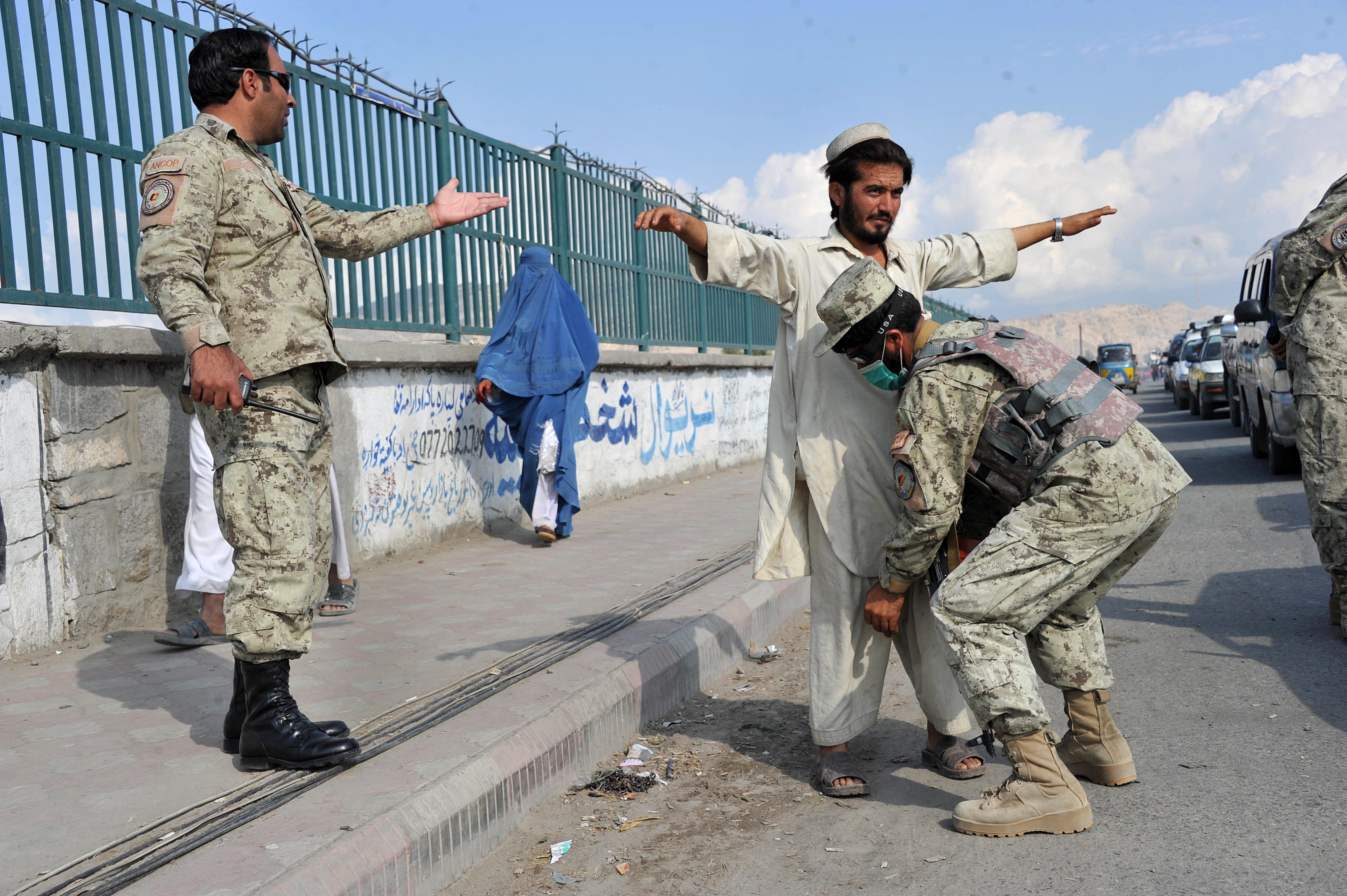 Afghan security personel check passengers and cars at a checkpoint in the city of Jalalabad in Nangarhar province on October 20, 2012. (AFP Photo/ Noorullah Shirzada)