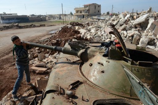 A Syrian boy plays with a destroyed army tank in the northern Syrian town of Azaz on October 29, 2012. (AFP PHOTO / PHILLIPE DESMAZES)