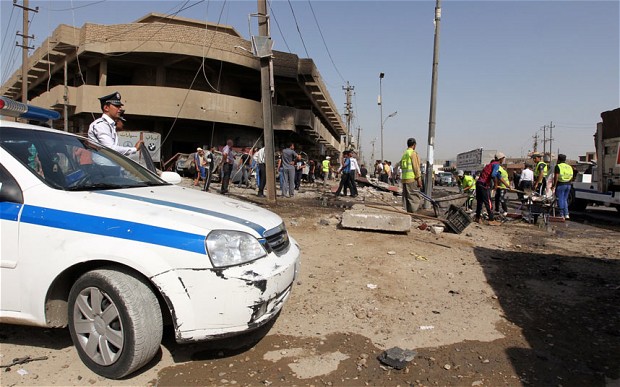 raqis inspect the site of a car bomb in central Baghdad Photo: SABAH ARAR/AFP/Getty Images
