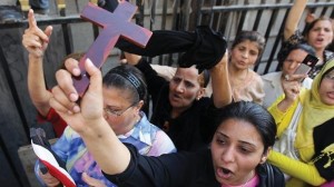 An Egyptian Coptic Christian raises a cross while others shout slogans during a demonstration outside the Cairo High Court. ( AFP File Photo/ Khaled Desouki)