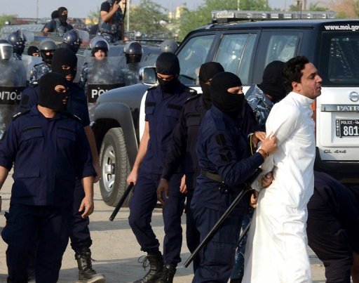 A protester is detained by Kuwaiti riot policemen. (AFP Photo/ Yasser al-Zayyat)