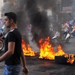 Protesters gather on motorbikes at a road block of burning tires in the northern Lebanese city for Tripoli as they demonstrate against the murder of General Wissam Al-Hassan. (AFP Photo)