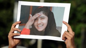 A Pakistani female activist of an Islamic Minhaj-ul-Quran Party holds a photograph of child activist Malala Yousafzai. (AFP PHOTO / AAMIR QUREISHI)