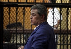 Tawfiq Okasha stands behind bars as he attends his trial on charge of calling for the murder of President Mohamed Morsi. (AFP Photo/ Ahmed Mahmud)