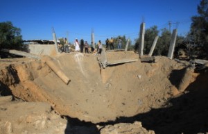 Palestinians inspects a crater following an Israeli attack in Al-Bureij center of the Gaza Strip on October 29, 2012. (AFP PHOTO / MAHMUD HAMS)