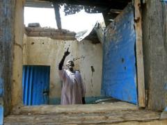 A man points to damage at his house caused by rebel fire.  (AFP/ Ashraf Shazly) 