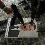 Free Syrian Army soldiers point guns at a portrait of President Bashar Al-Assad. (AFP PHOTO / ADEM ALTAN)