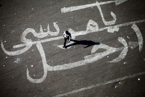 A man walks over a graffiti reading "Morsy Go" on Tahrir square in Cairo. (AFP PHOTO / MAHMOUD KHALED)