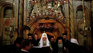 Greek Orthodox Patriarch of Jerusalem Theophilos III (right) and Russian Orthodox Patriarch Kirill (centre) pray in front of Christ's tomb at the Church of the Holy Sepulchre. (AFP / FILE PHOTO / GALI TIBBON)