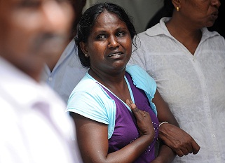 Nimali Perera, the wife of a Sri Lankan inmate killed during a prison riot weeps outside the police morgue after an autopsy in Colombo. (AFP PHOTO / Ishara S. KODIKARA)